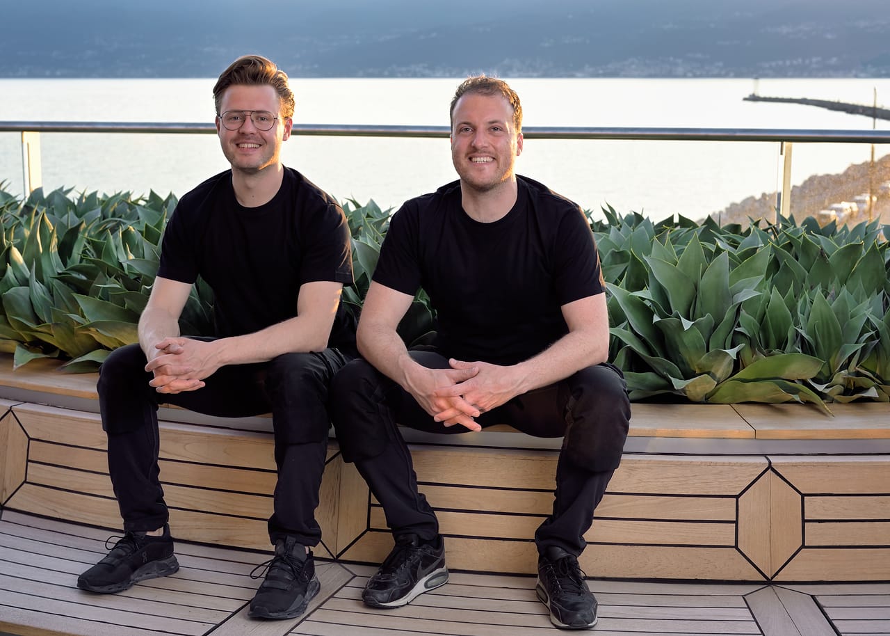 Luc en Leo van Calamai tussen kunstplanten aan dek van cruiseschip Scenic Eclipse.
