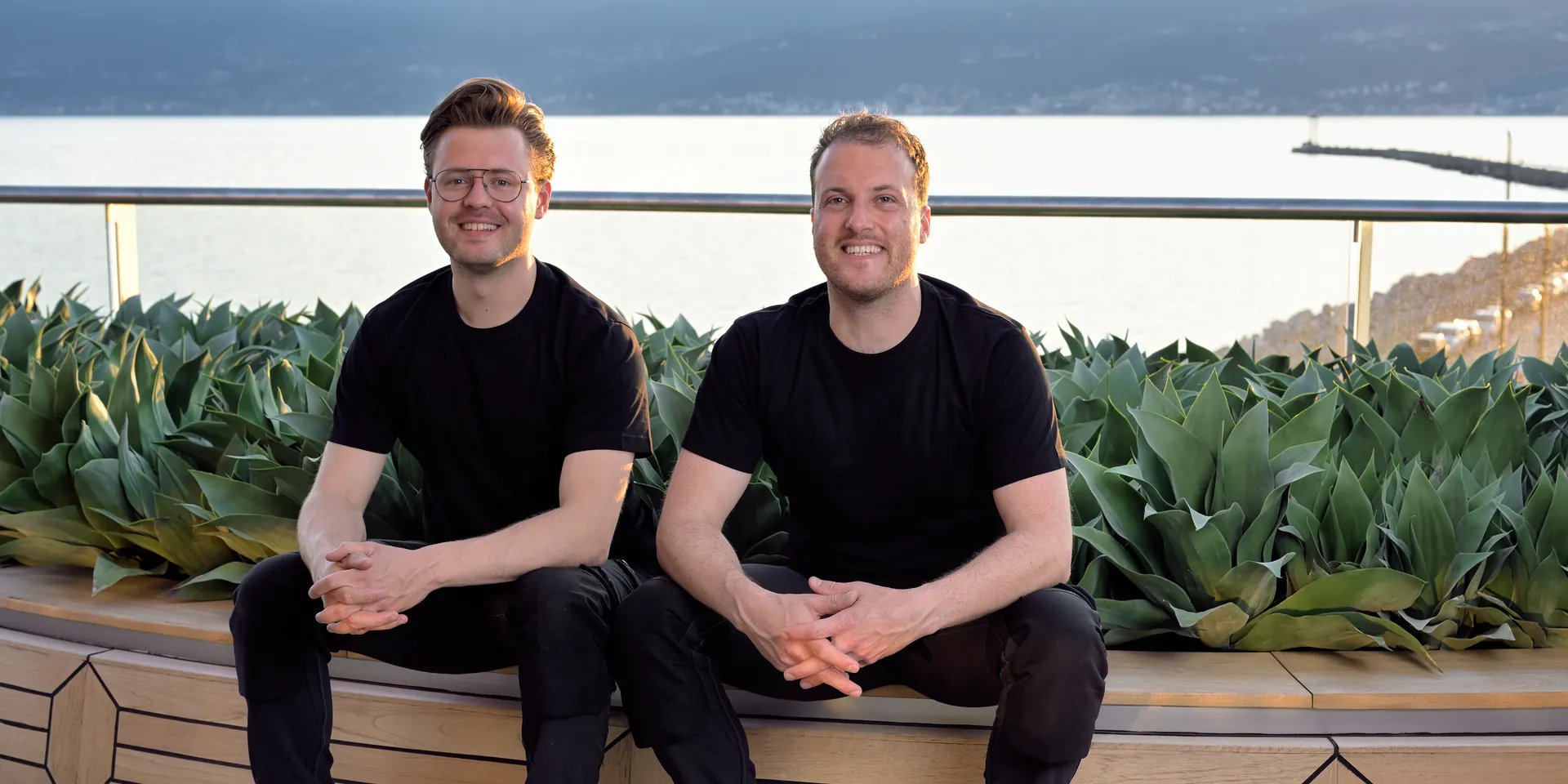 Luc en Leo van Calamai tussen kunstplanten aan dek van cruiseschip Scenic Eclipse.