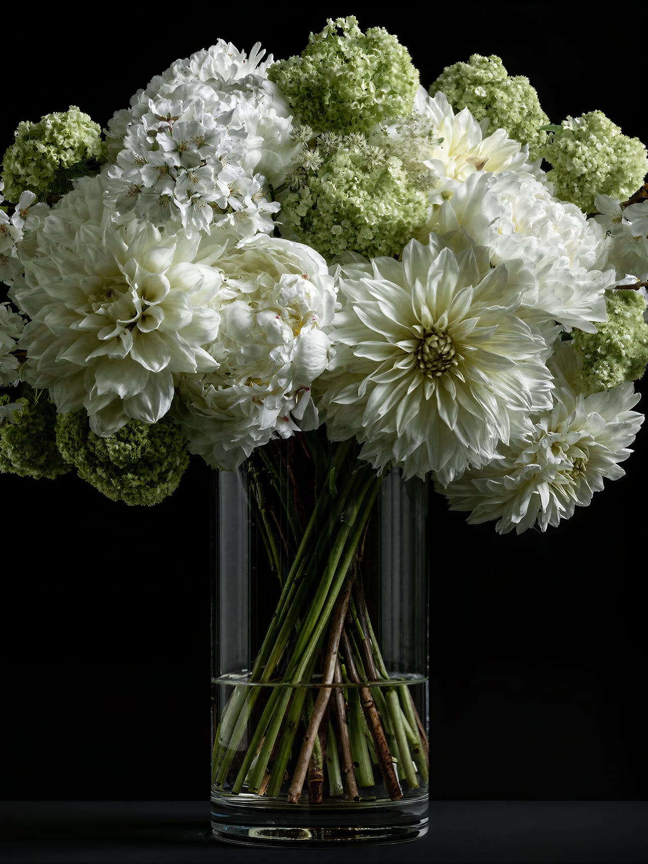 Boeket kunstbloemen van Calamai: witte dahlia's, pioenrozen en sneeuwbal in glazen vaas.